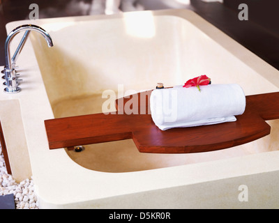 Badewanne mit Handtuch am Holzregal Stockfoto