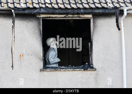 Untersuchung der Feuerwehrführungskräfte untersuchen die Szene einen tödlichen Hausbrand zu bestimmen, die Ursache des Vorfalls. Stockfoto