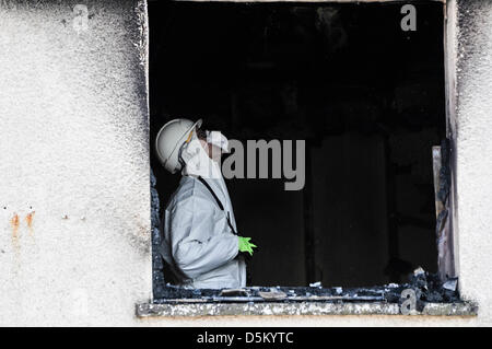 Untersuchung der Feuerwehrführungskräfte untersuchen die Szene einen tödlichen Hausbrand zu bestimmen, die Ursache des Vorfalls. Stockfoto