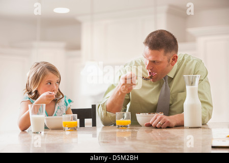 Vater und Tochter (6-7) Essen Frühstück Stockfoto