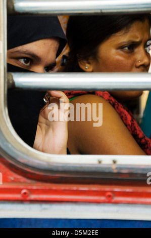 Muslimische Frau sitzt neben Hindu-Frau in einem Bus in Mumbai, Maharashtra, Indien Stockfoto