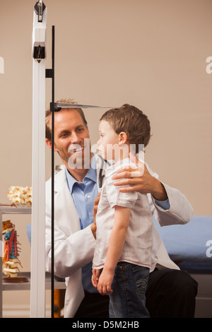 Junge (2-3) auf der Skala in Arztpraxis Stockfoto