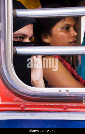 Muslimische Frau sitzt neben Hindu-Frau in einem Bus in Mumbai, Maharashtra, Indien Stockfoto