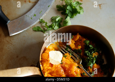 Kartoffelpüree, Süßkartoffeln oder Yams in einer Kupfer Pfanne mit Koriander und einer Mezza Luna Stockfoto