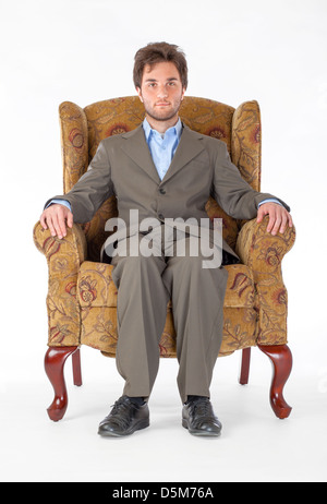 Ein junger Mann sitzt auf einem Stuhl. Stockfoto
