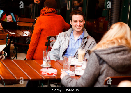 Zwei Personen im Chat in den offenen Straßencafé am Naschmarkt (Open-Air-Markt) in Wien, Österreich Stockfoto