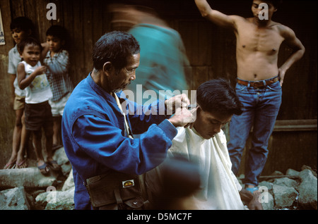 Straße Friseur einen Haarschnitt zu geben, wie Kinder aussehen auf. Mount Apo, Mindanao. Die Philippinen. Stockfoto