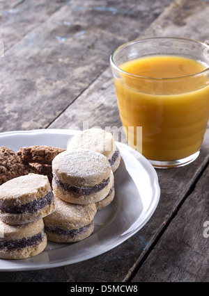 Kekse und Saft auf alten Holztisch, Nahaufnahme Stockfoto