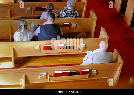 Einsame ältere Mann in der Kirche hinter dem jungen Paar. Stockfoto