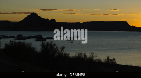 Dawn Boote orange Himmel Blick aufs Wasser von Lake Powell Resort auf Silhouette "Castle Rock" Mesa Küste, Lake Powell, Arizona, USA Stockfoto