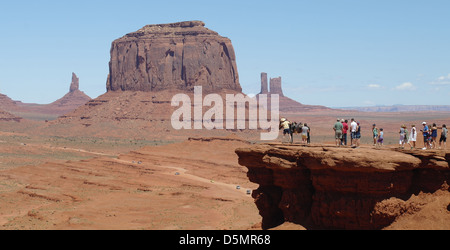 Blauer Himmelsblick auf Merrick Butte, Touristen zu Fuß in Richtung Cowboy Pferd, John Ford Point, Monument Valley, Arizona, USA Stockfoto