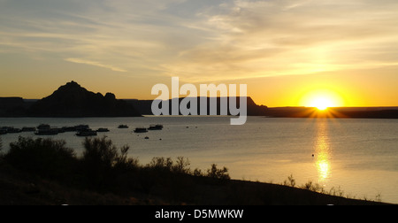 Blick vom Lake Powell Resort auf Silhouette Küste "Castle Rock" und gelb leuchtendes Wasser Sonnenaufgang Lake Powell, Arizona, USA Stockfoto