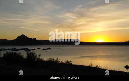 Blick vom Lake Powell Resort über Wasser auf 'Castle Rock' und gelbe Sonne Silhouette Küstenlinie, Lake Powell, Arizona, USA Stockfoto