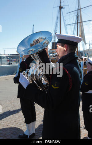 Kopenhagen, Dänemark. 4. April 2013. Tuba-Spieler aus der königlichen dänischen Marine Band begleitet die Kadetten an der Royal Danish Naval Academy bei ihren "Flagge an Bord" Parade vor die beiden Schiffe der Marine Training am Amaliehaven Quay im Hafen von Kopenhagen. Stockfoto