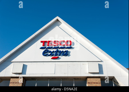 Detail von einem Tesco extra Gebäude Dach mit Zeichen und Logos Huntingdon UK vor blauem Himmel Stockfoto