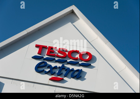 Detail von einem Tesco extra Gebäude Dach mit Zeichen und Logos Huntingdon UK vor blauem Himmel Stockfoto