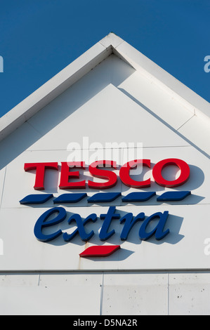 Detail von einem Tesco extra Gebäude Dach mit Zeichen und Logos Huntingdon UK vor blauem Himmel Stockfoto