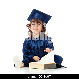 Kleine Mädchen in Akademiemitglied Kleidung mit Buch Stockfoto