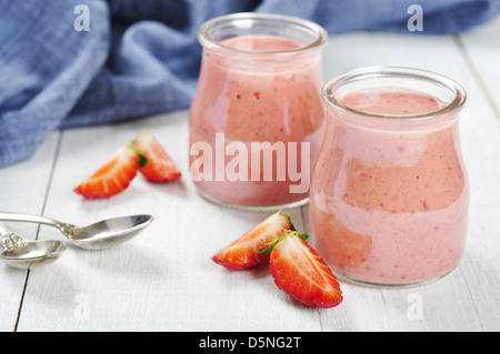 Erdbeer-Dessert in Gläsern und frische Erdbeeren auf einem hölzernen Hintergrund Stockfoto
