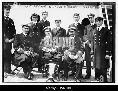 Dieses Foto zeigt Captain Rostron und seine Offiziere an Bord der RMS Carpathia, einem Ozeanschiff, das vor allem für seine Rolle bei der Rettung der Überlebenden der Titanic-Katastrophe im Jahr 1912 bekannt ist. Die Crew wird in ihren Uniformen an Bord des Schiffes gezeigt. Stockfoto