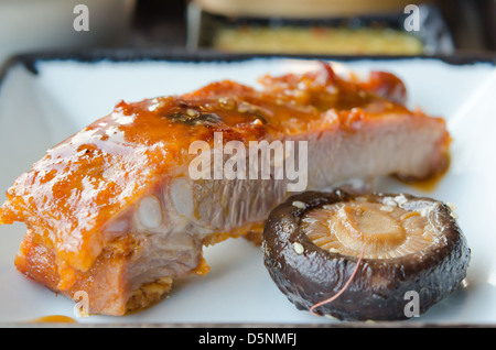 Nahaufnahme von Schweinefleisch Spareribs mit roter Soße und Pilzen Stockfoto