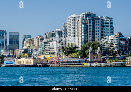 Luna Park Vergnügungspark am Hafen von Sydney, mit der Skyline des zentralen Geschäftsviertels von North Sydney im Hintergrund, New South Wales, Australien. Stockfoto
