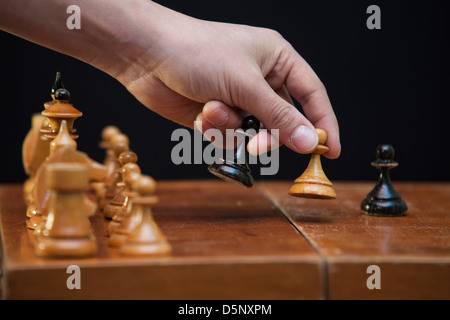 Die Figuren auf dem Brett platziert, die Hand eines Mannes Bewegung verpfänden Stockfoto