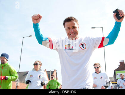 Liverpool, Vereinigtes Königreich. 6. April 2013. Big Brother Winner Craig Phillips (Zentrum Prominente) jubelt wie er Läufer über die Ziellinie der ihre 96 Meile Charity-Lauf von Hillsborough, Anfield Credit verbindet: Andy Thornley / Alamy Live News Stockfoto