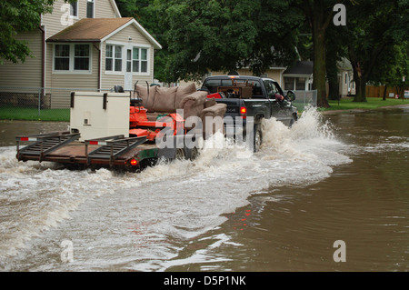 Dieses Bild zeigt ein Coast Salish Kanu, zusammen mit Daten der USGS über Wasserqualität und Überschwemmungen im Mittleren Westen von Iowa. Die Gegenüberstellung des Kanus mit den modernen Hochwasserdaten unterstreicht den Kontrast zwischen traditionellen einheimischen Wasserfahrzeugen und zeitgenössischen Umweltbelangen. Stockfoto