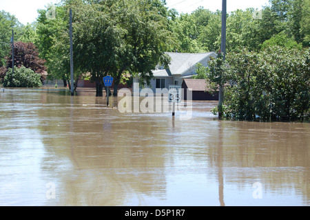 Dieses Bild zeigt ein Kanu der Coast Salish, das die Verbindung zwischen indigenen Kulturen und Wassersystemen symbolisiert. Außerdem wird auf das Problem der Überschwemmungen in Iowa und im Mittleren Westen hingewiesen, wobei die USGS Daten über die Wasserqualität und die Hochwasserüberwachung gesammelt hat. Stockfoto
