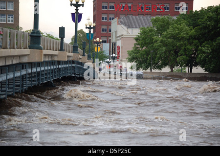 Dieses Bild zeigt ein Kanu, das von den Coast Salish-Menschen benutzt wird, die durch Überschwemmungen im Mittleren Westen der Vereinigten Staaten, insbesondere in Iowa, navigieren. Es werden Fragen der Wasserqualität im Zusammenhang mit Naturkatastrophen und Überschwemmungen hervorgehoben. Stockfoto