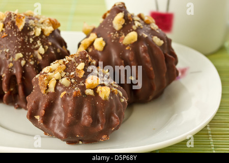 Schokoladenkuchen, gefüllt mit Nüssen und Untertasse Stockfoto