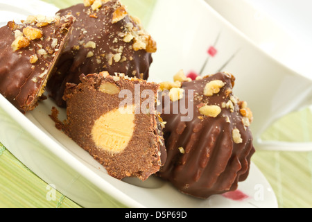 Schokoladenkuchen, gefüllt mit Nüssen und Untertasse Stockfoto