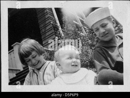 Ein Foto mit Helen Richey, der ersten Frau, die ein kommerzielles Flugzeug in den Vereinigten Staaten fliegt, mit einem Kind, möglicherweise einem Jungen, der eine Matrosenmütze trägt, und einem weiteren Kind, möglicherweise einem Mädchen. Sie sind draußen, lächeln und fangen einen fröhlichen Moment in einer Umgebung im Freien ein. Stockfoto