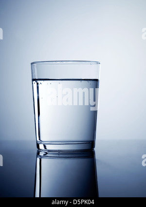 Glas mit frischem Wasser, mit blau gefärbt Stockfoto