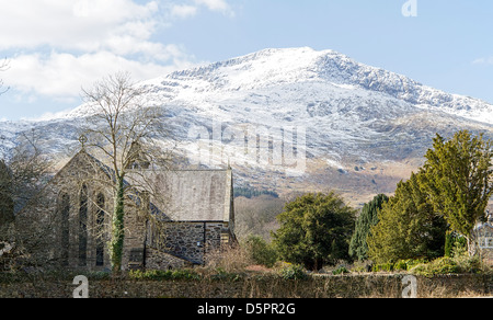 Schneebedeckte Berg mit St Marys Kirche in Beddgelert, Nordwales Stockfoto