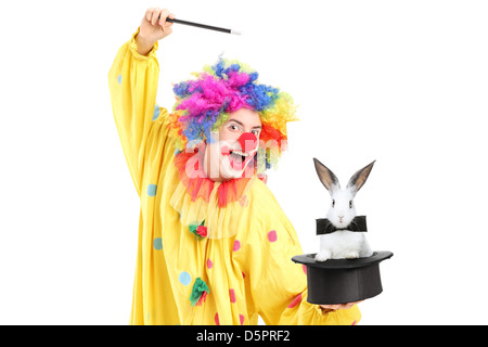 Ein Zirkusclown Durchführung einen Zaubertrick mit einem Zylinder und ein Kaninchen isoliert auf weißem Hintergrund Stockfoto
