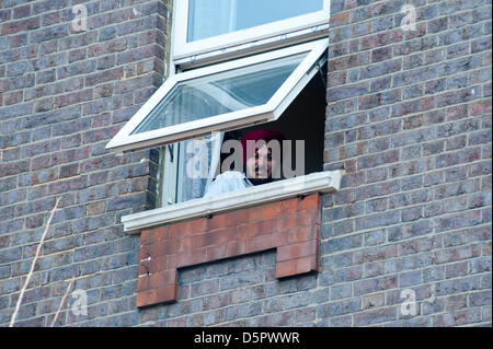 London, UK. 7. April 2013. Ein Sikh Mann Uhren die Prozession aus dem Fenster seines Hauses während der Feier von Nagar Kirtan in Southall, London. Bildnachweis: Piero Cruciatti/Alamy Live-Nachrichten Stockfoto