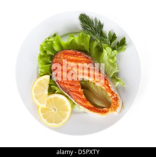 Gegrillter Lachs mit Zitronenscheiben und Kräutern auf Platte. Isoliert auf weißem Hintergrund Stockfoto