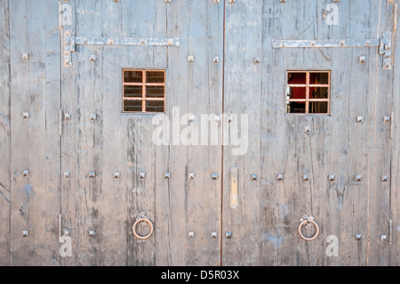 seltsame Holztür mit zwei vergitterten Fenstern Stockfoto