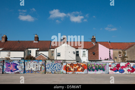 Reihe von Reihenhäusern mit Graffiti bedeckt wieder Gartenmauer Stockfoto