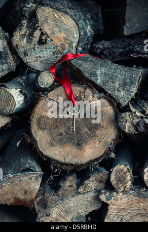 einen alten Schlüssel mit einem roten Band am Holz liegen Stockfoto