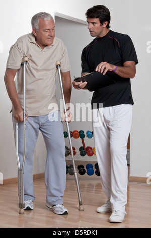 Patienten auf Krücken und Arzt Stockfoto