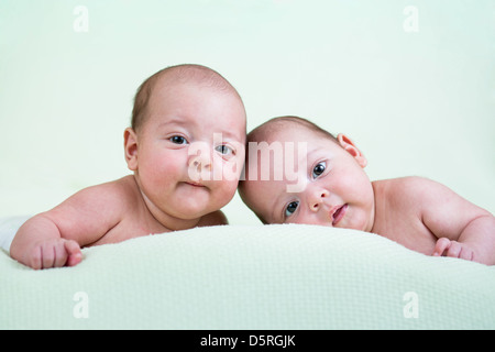 lustige neugeborenen Zwillinge auf Bauch liegend Stockfoto