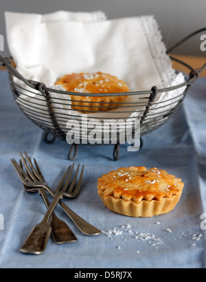 Fruchttorte mit Besteck mit einem Korb von Torten in den Hintergrund. Stockfoto