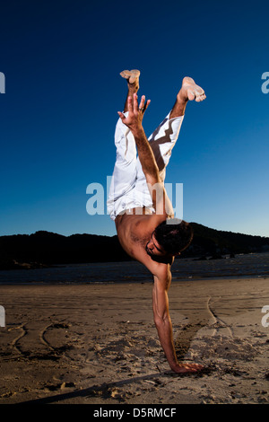 Mann tut "Capoeira" Martial Arts am Strand Stockfoto