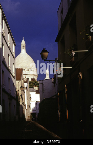 Blick auf die römisch-katholische Basilika des Heiligen Herzens von Paris, allgemein bekannt als Sacré-Cœur Basilika, wie aus einer engen Gasse in Montmartre im 18. Arrondissement, Paris Frankreich gesehen Stockfoto