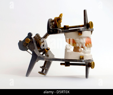 Prothesen, die isoliert auf einem weißen Hintergrund auf grau metallic Artikulator für Zahntechniker Stockfoto