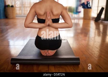 Eine junge Frau beim Yoga, hier die Hände im Gebet hinter Rücken. Umgekehrte Gebet darstellen. Oaxaca-Stadt, Mexiko. Stockfoto
