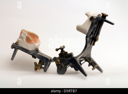 Prothesen, die isoliert auf einem weißen Hintergrund auf grau metallic Artikulator für Zahntechniker Stockfoto